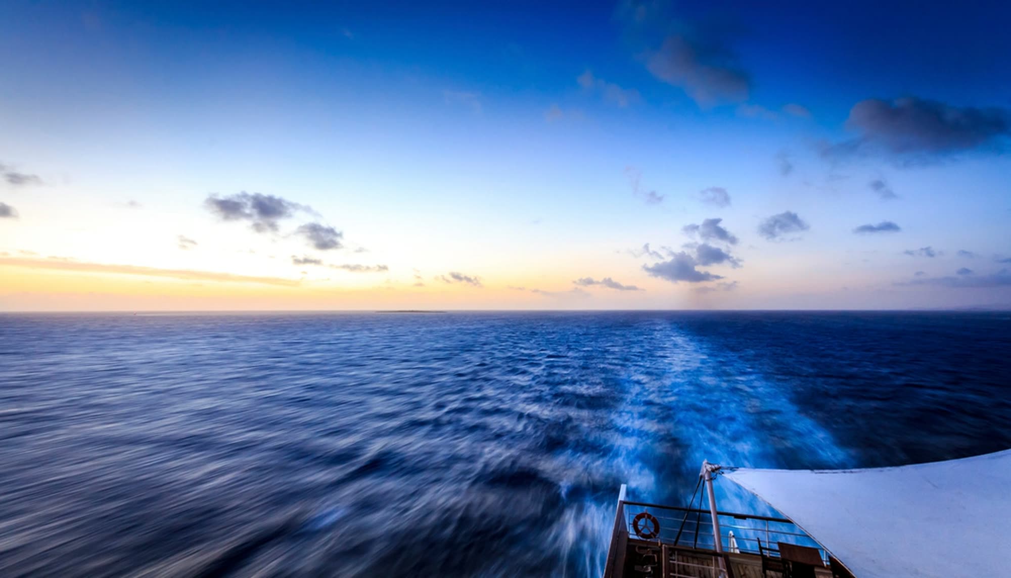 The open sea at sunset seen from a ship’s deck